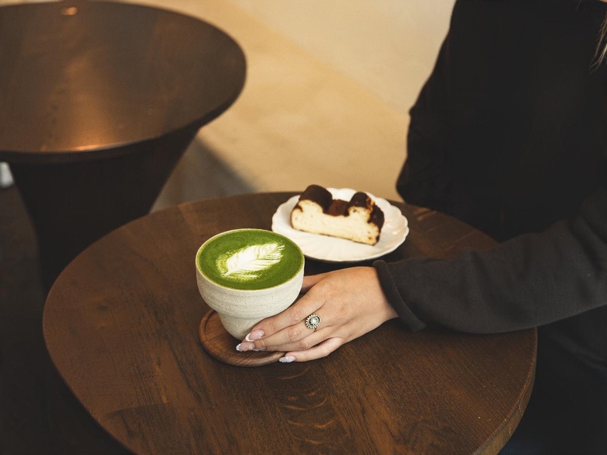 Matcha latte with latte art and house-made Basque cheesecake served at Rakia Coffee in Jacksonville, Florida.