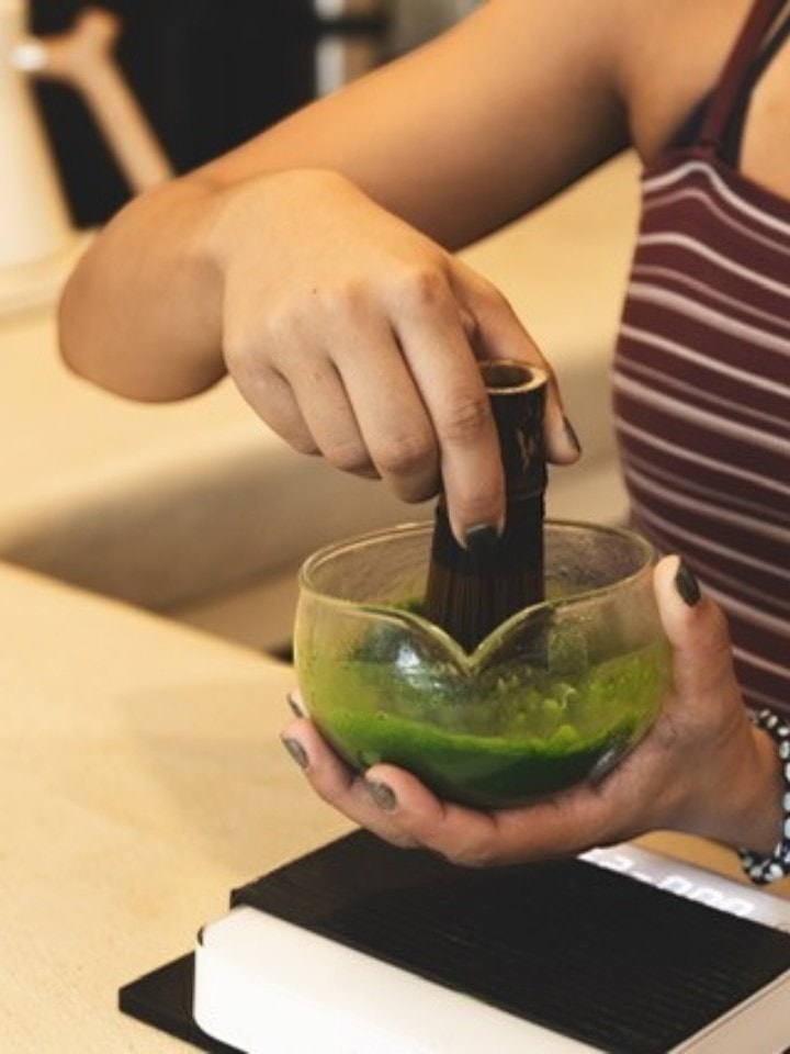 Fresh Japanese matcha being whisked by hand in a glass bowl at Rakia Coffee in Jacksonville.